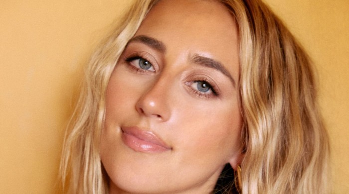 A close up image of a blonde woman with wavy hair